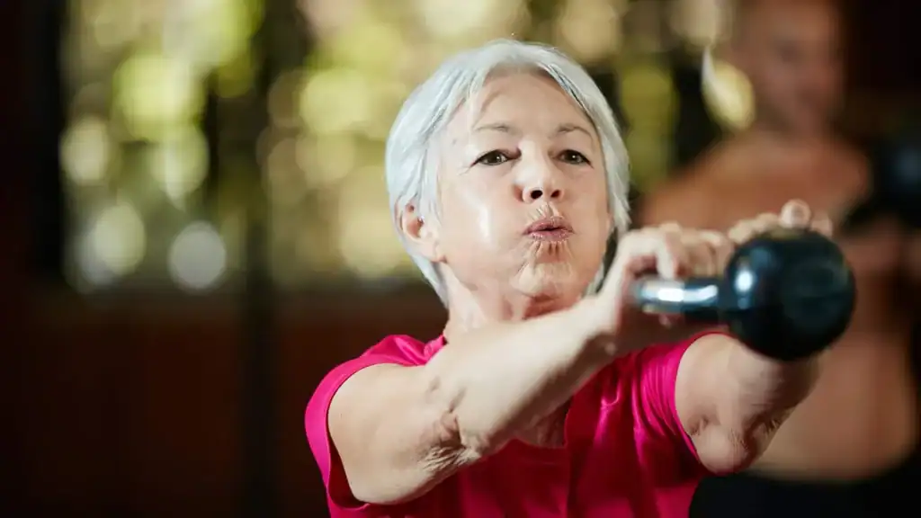 Older woman doing weight training Worthing to help her strength and longevity 