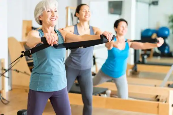 Toning Arms After 60: Empowering Womens Fitness Through Effective Weight Training 2 older woman doing weight training Worthing and resistance in the gym to tone upper arms